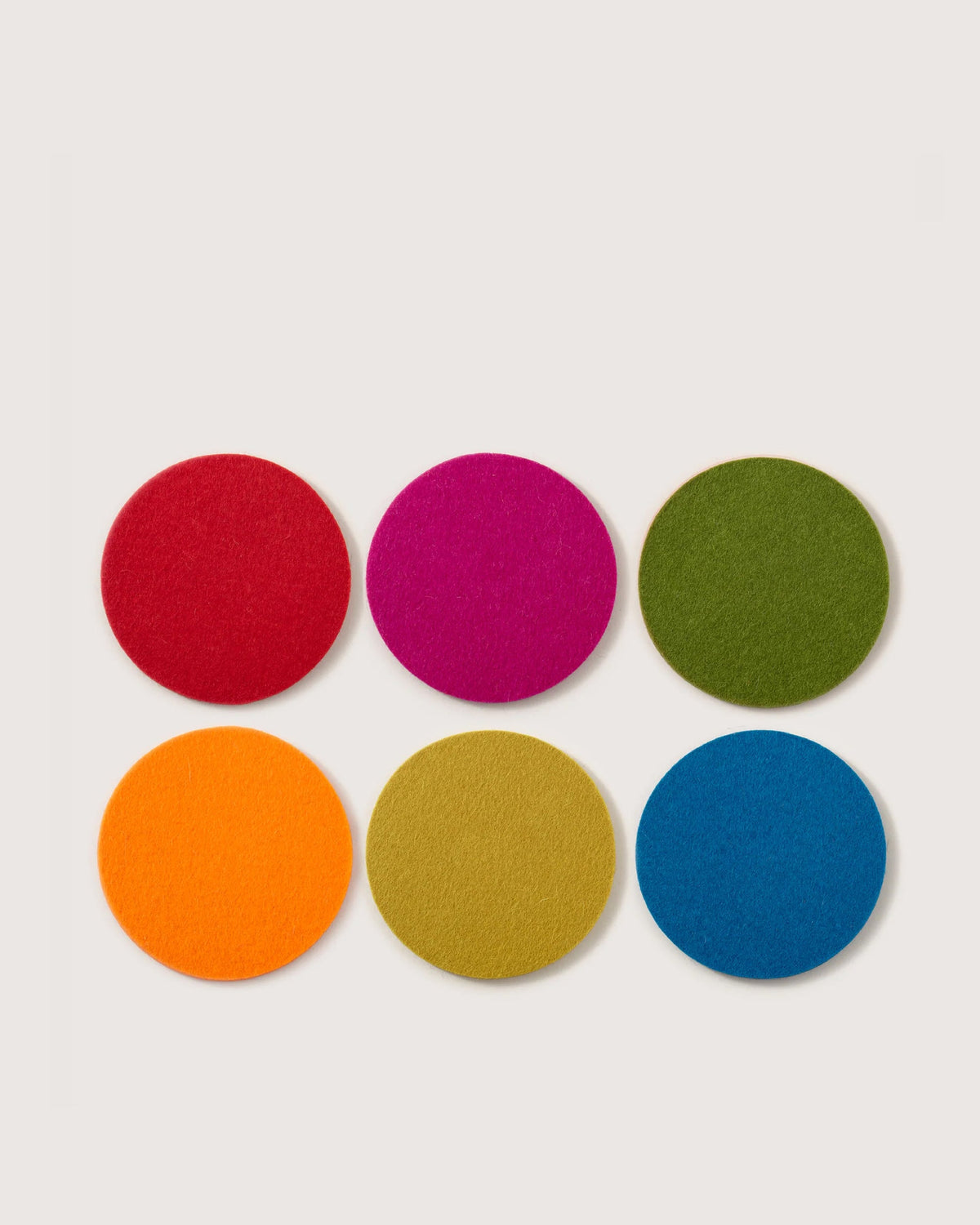 Six round Merino wool felt coasters in rainbow colors